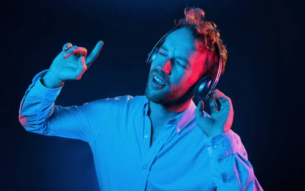 Hört Die Musik Neonbeleuchtung Junger Europäischer Mann Ist Dunklen Studio — Stockfoto