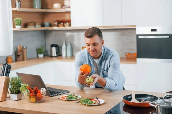 Man preparing food at home on the modern kitchen.