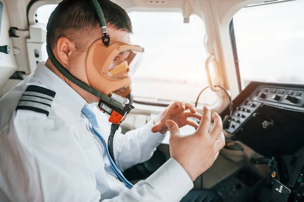 In oxygen mask. Pilot on the work in the passenger airplane. Preparing for takeoff.