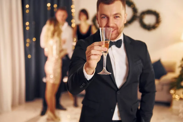 Чоловік Склянкою Шампанського Веселить Група Людей Влаштовує Новорічну Вечірку Приміщенні — стокове фото