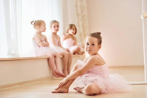 女孩们坐在窗台上和地板上 准备表演的小芭蕾舞演员 — 图库照片