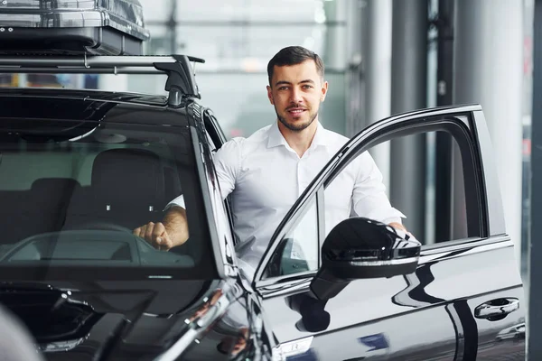 Jongeman Wit Shirt Binnen Met Moderne Nieuwe Auto — Stockfoto