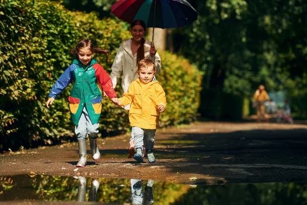 Manzara Anne Küçük Oğlu Kızıyla Yağmurdan Sonra Parkta Yürüyüşe Çıktı — Stok fotoğraf