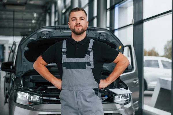 Pie Contra Coche Hombre Uniforme Trabaja Autosalón Durante Día — Foto de Stock