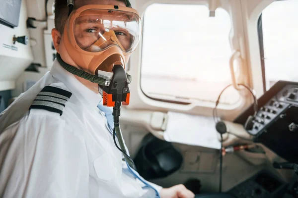 In oxygen mask. Pilot on the work in the passenger airplane. Preparing for takeoff.