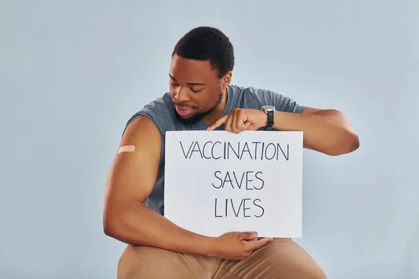 Vaccination saves lives banner. Young african american man after vaccine injection.