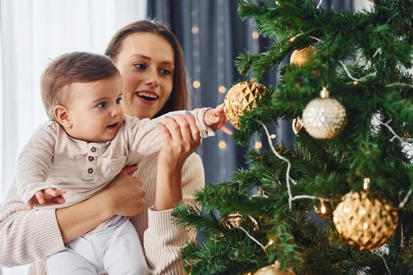 クリスマスツリーを飾る 母親と娘は屋内で一緒に家にいる — ストック写真