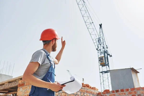 Uma Papelada Jovem Trabalhador Construção Uniforme Está Ocupado Edifício Inacabado — Fotografia de Stock