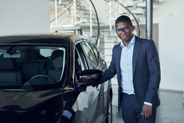 Arabaya bakıyorum. Siyah takım elbiseli genç Afro-Amerikan iş adamı Ototalon..