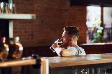 Bar barı. Sıradan elbiseli bir adam içeride oturuyor..