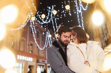 Birbirinize sarılın. Mutlu genç çift sokakta yeni yılı kutluyor..