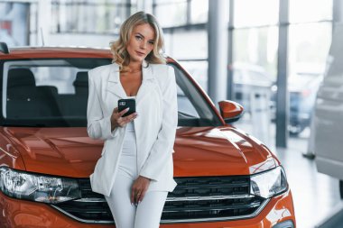 Telefonla. Resmi giyinmiş bir kadın otosalon 'da içeride..