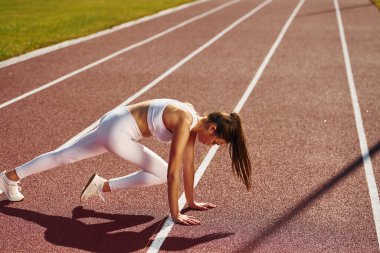 Esneme egzersizleri. Spor elbiseli genç bayan dışarıda spor yapıyor..