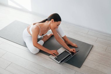 Yoga minderinde. İnce vücutlu beyaz kadın gündüz vakti evdedir..