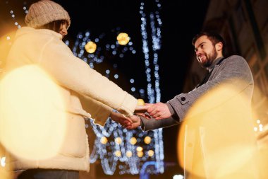 El ele tutuşarak. Mutlu genç çift sokakta yeni yılı kutluyor..