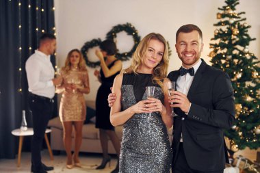 Güzel bir çift. Bir grup insan içeride yeni yıl partisi veriyor..
