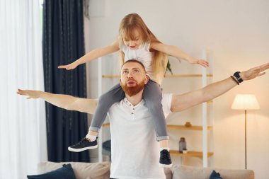 Omuzlarında oturan kız. Baba ve küçük kızı evde birlikteler..