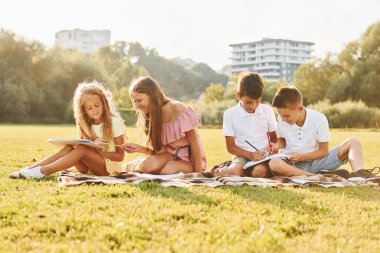 Hobi kavramı. Bir grup mutlu çocuk gündüz vakti spor sahasında..