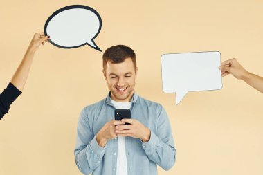 Akıllı telefonu tutuyorsun. Bir sürü fikir. Stüdyoda duran adam mesaj için boş tabelalarla.