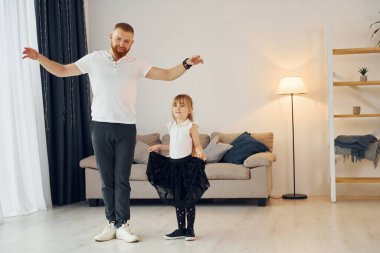 Yoga pozları. Baba ve küçük kızı evde birlikteler..