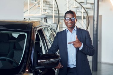 Anahtarları elinde tutuyor. Siyah takım elbiseli genç Afro-Amerikan iş adamı Ototalon..