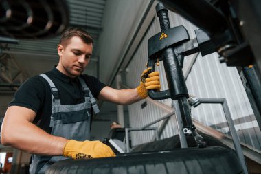 Güçlü eller. Üniformalı adam otomobil servisinde çalışıyor..