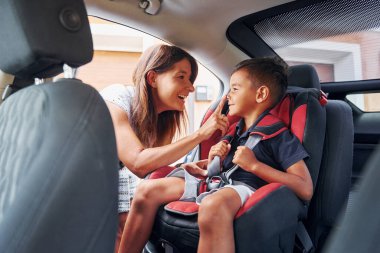 Küçük çocuklu kadın gündüz vakti modern otomobilde..