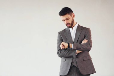 Beyaz arka planda kamera için poz vermek. Takım elbiseli genç bir işadamı..