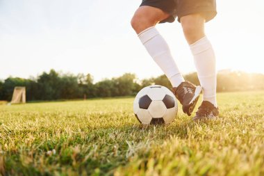 Manzarayı kapat. Genç futbolcu spor sahasında antrenman yapıyor..