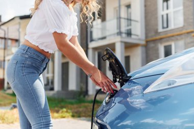 Manzarayı kapat. Gündüz vakti elektro-mobil arabasıyla gezen genç bir kadın..