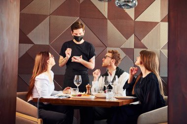 İnsanlar birlikte akşam yemeği yer. Yeni lüks restoranın içinde..