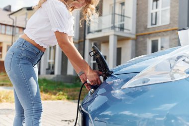 Manzarayı kapat. Gündüz vakti elektro-mobil arabasıyla gezen genç bir kadın..