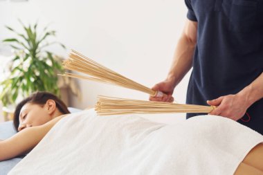 Özel ekipman. Genç bir kadın, erkek kaplıcada vücuduna masaj yaparken uzanır..