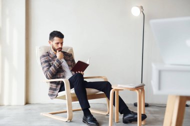 Kitap okuyor. Takım elbiseli genç bir iş adamı. Başarı kavramı.