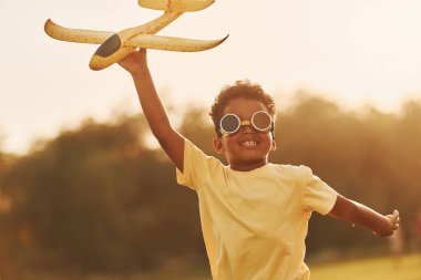 Hayal gücünün gücü. Pilot oyunu oynuyoruz. Afrikalı Amerikalı çocuk yaz günlerinde tarlada eğleniyor..