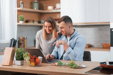 Birlikte hafta sonu geçirmek. Modern mutfakta yemek hazırlayan bir çift..