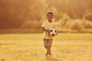 Aktif hafta sonu harcamaları. Afrikalı Amerikalı çocuk yaz günlerinde tarlada eğleniyor..