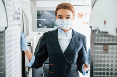 Maskeli. Yolcu uçağında çalışan genç hostes..