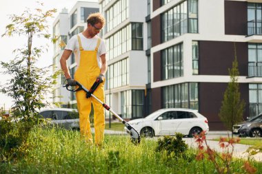 Bir kişi. Bahçede çimleri çim biçen bir adam var..
