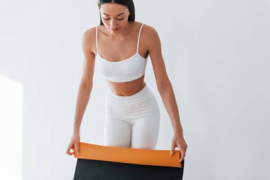 Ellerinde hasırla. İnce vücutlu beyaz kadın gündüz vakti evdedir..