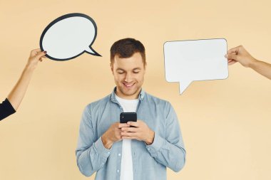 Akıllı telefonu tutuyorsun. Bir sürü fikir. Stüdyoda duran adam mesaj için boş tabelalarla.