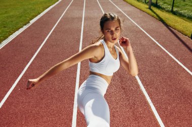 Dövüş teknikleri çalışıyorum. Spor elbiseli genç bayan dışarıda egzersiz yapıyor..