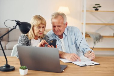 Masada dizüstü bilgisayarla. Büyük adam ve kadın evde birlikteler..