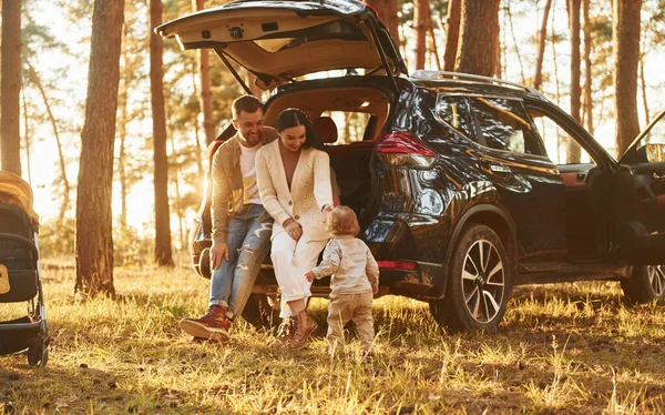車の中でリース 父と母と娘の幸せな家族が森の中にいる — ストック写真