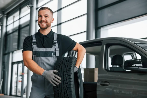 Neumático Nuevo Hombre Uniforme Trabaja Autosalón Durante Día — Foto de Stock