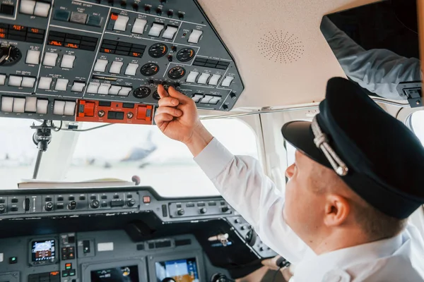 Close up view. Pilot on the work in the passenger airplane. Preparing for takeoff.