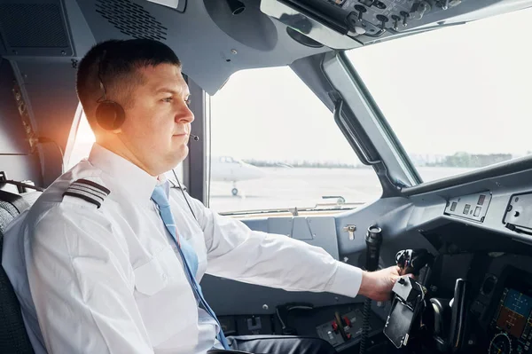 Side view. Pilot in formal wear sits in the cockpit and controls airplane.