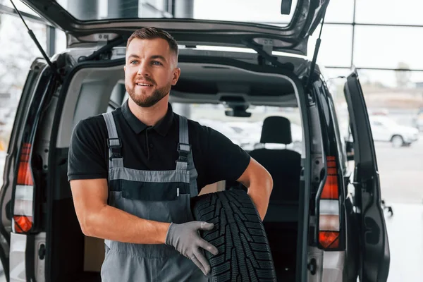 Sostiene Neumático Hombre Uniforme Trabaja Autosalón Durante Día — Foto de Stock