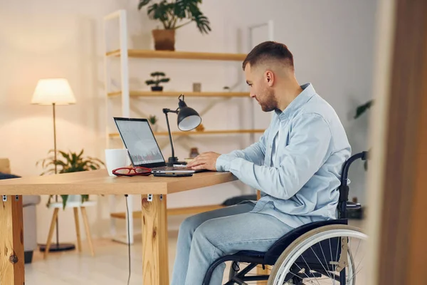 Business worker. Disabled man in wheelchair is at home.