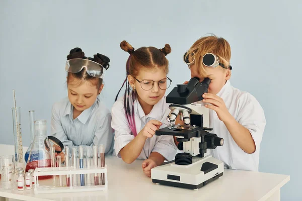 Usando Microscópio Crianças Casacos Brancos Joga Cientistas Laboratório Usando Equipamentos — Fotografia de Stock